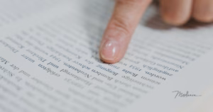 Finger zeigt auf Zeilen in einem offenen Buch