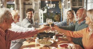 Familie prostet sich am Tisch zu