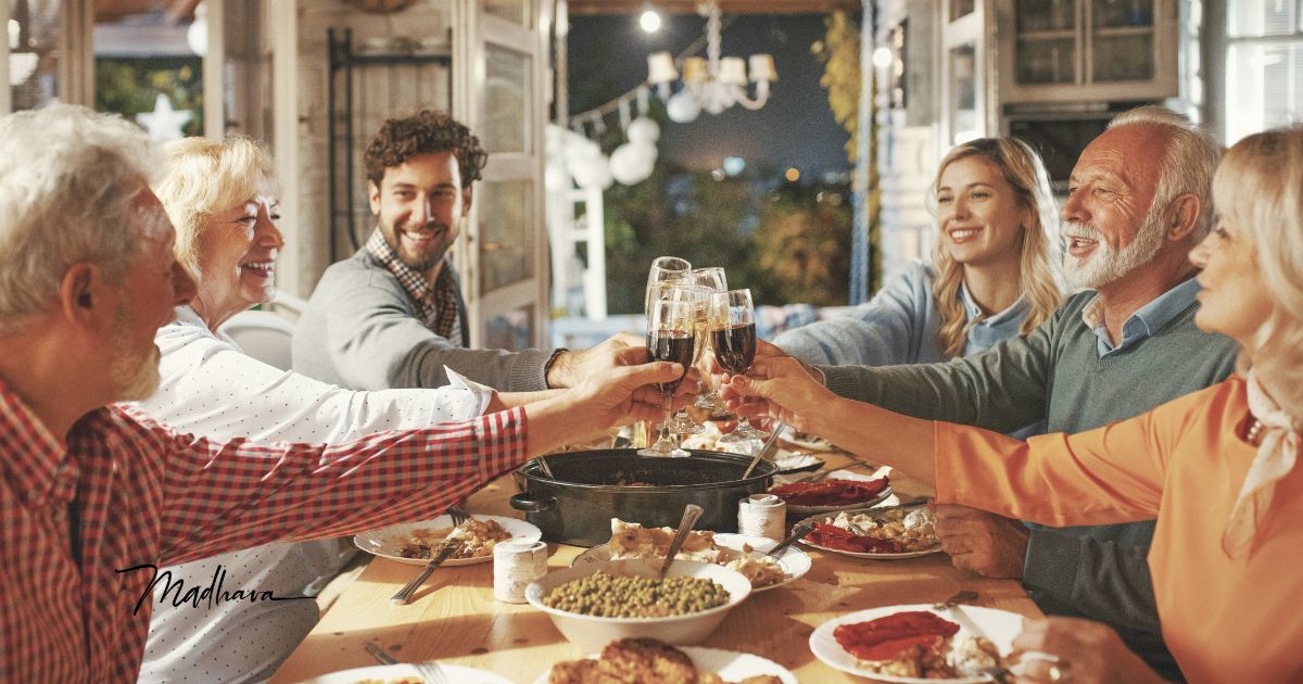 Familie prostet sich am Tisch zu