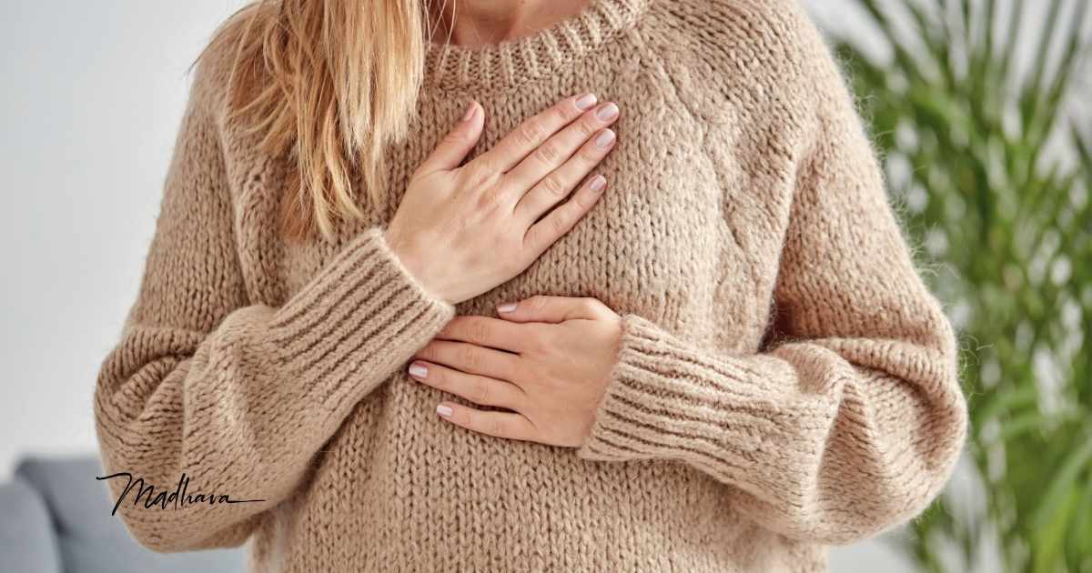 Frau hat Hand auf Herz und Bauch