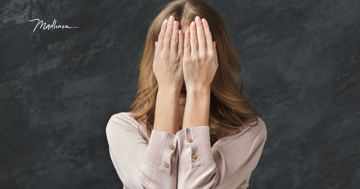 Frau hält sich beide Hände vor das Gesicht