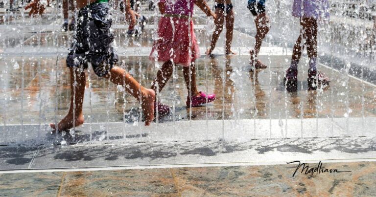 Kinder die im Brunnen spielen