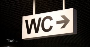 ein WC Hinweisschild mit Pfeil