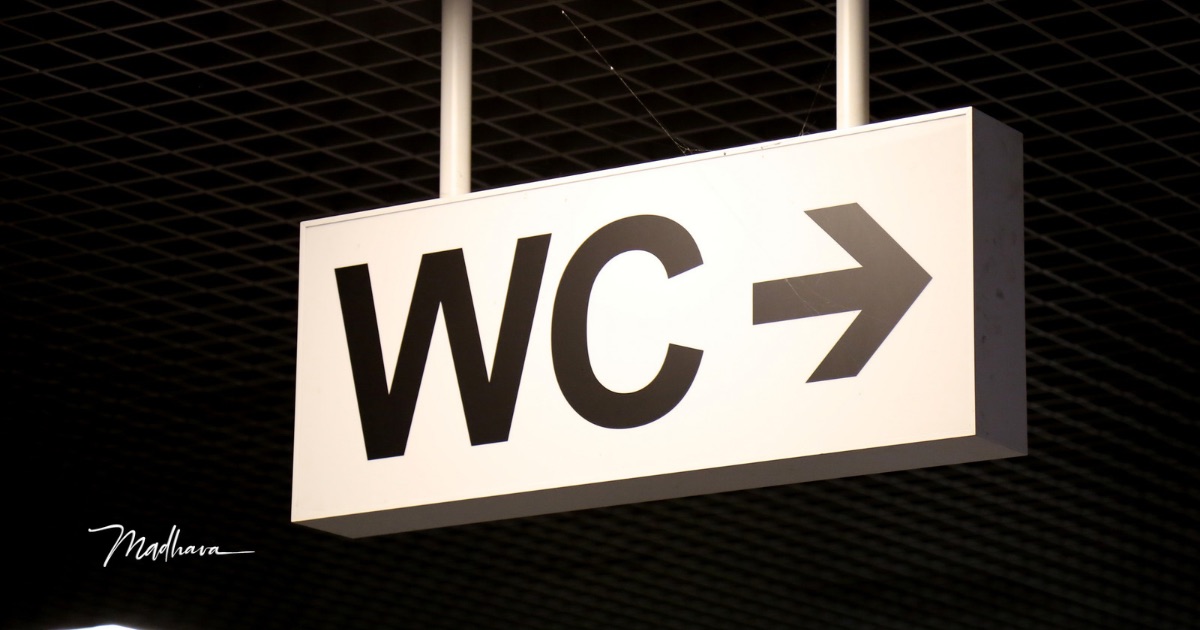ein WC Hinweisschild mit Pfeil